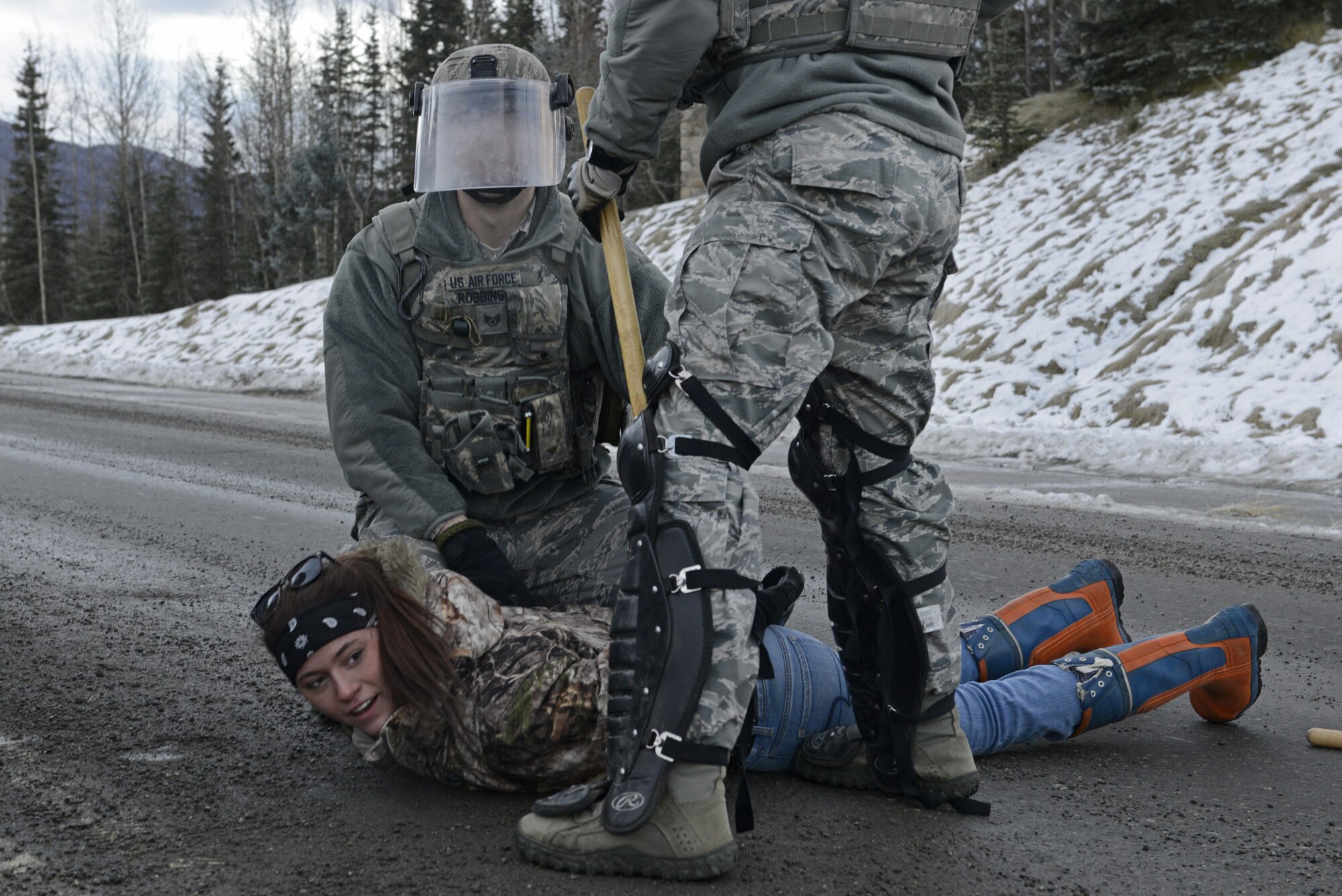 Joint Base Elmendorf-Richardson security forces personnel perform security operations during a simulated protest as part of exercise Polar Force 17-1 at JBER, Alaska, Nov. 1, 2016. The simulated protest began as a peaceful demonstration which escalated, resulting in a few aggressive protesters being detained and turned over to local law enforcement. The exercise tests the base's ability to integrate, mobilize, and prepare assigned personnel, aircraft and equipment for a wartime mission and to employ forces and weapons systems. 
