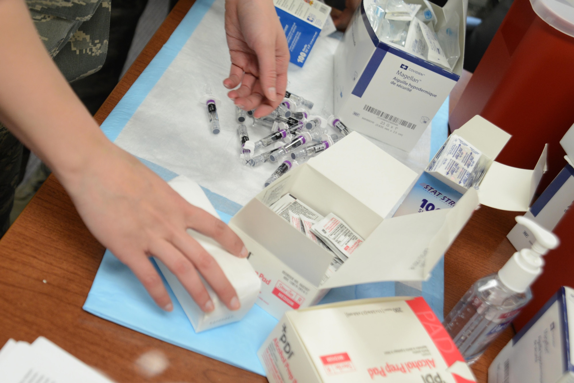 Senior Airman Casie Neiman, 673d Medical Operational Support Allergy and Immunizations backup technician, prepares equipment for a flu vaccination line at the People Center at Joint Base Elmendorf-Richardson, Alaska, Oct. 5, 2016. The flu line was an option for groups of more than 40 people to receive their influenza shot instead of going to the Allergy and Immunizations clinic. 