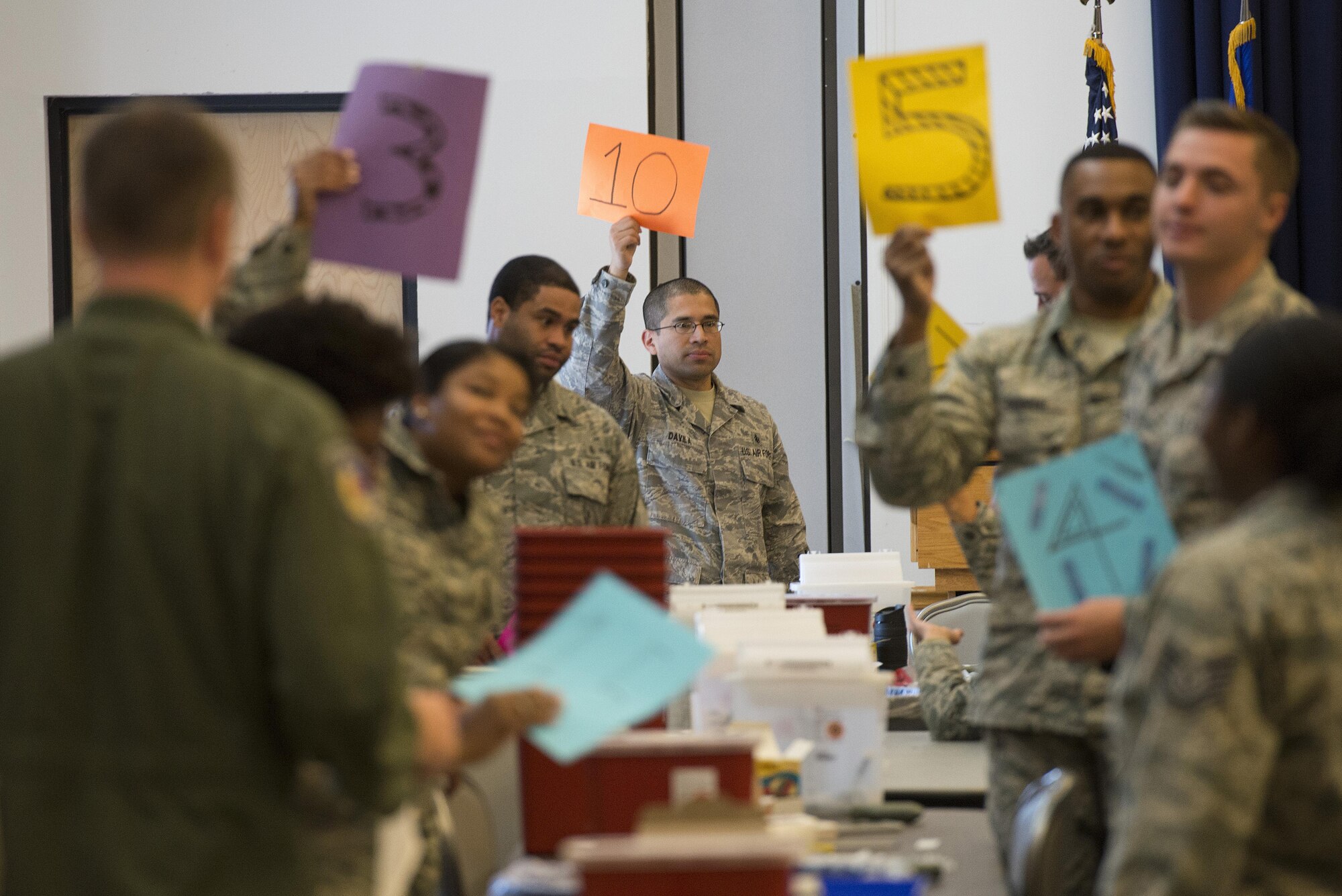 Airmen of the 436th and 166th Medical Groups hold up numbered signs signifying they are available to accept a patient during a 436th MDG point of distribution exercise Oct. 25, 2016, at the Landings on Dover Air Force Base, Del. Twenty-one medical Airmen administered 1,205 vaccines during the 13-hour event. (U.S. Air Force photo by Senior Airman Aaron J. Jenne)
