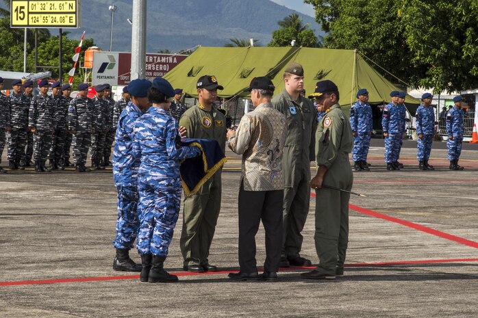 U.S. Marine Corps Capt. Bryan Boer, a pilot with All-Weather Fighter Attack Squadron (VMFA (AW)) 225, and an Indonesian Air Force pilot, participate in a traditional patch exchange during the Cope West 17 opening ceremony at Sam Ratulangi International Airport, Indonesia, Nov. 1, 2016. The Charge de Affairs, Brian McFeeters, replaces the pilots; patches with the Cope West patch, symbolizing the commencement of the exercise. (U.S. Marine Corps photo by Cpl. Aaron Henson)