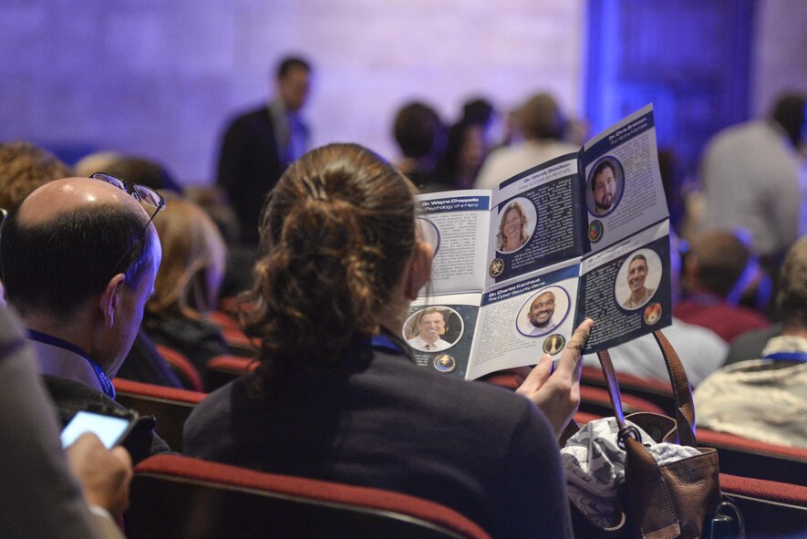 An audience member reads over the official program for the second annual AFRL Inspire event at the Dayton Art Institute Oct. 26. A line up of six speakers from across AFRL delivered 12-17 minute talks about various research achievements with each featuring AFRL scientists and engineers tackling challenges for the benefit of Airmen and society. (U.S. Air Force photo/Wesley Farnsworth)