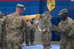 Col. Stephen M. Bousquet, commander of the 369th Sustainment Brigade, 1st Sustainment Command (Theater), and Command Sgt. Maj. Anthony V. Mclean, the brigade’s senior enlisted advisor, uncase the brigade’s unit colors during a ceremony held at Camp Arifjan, Kuwait on October 26, 2016, symbolizing the transfer of authority from the 17th Sustainment Brigade. (U.S. Army National Guard photo by Sgt. Cesar Leon/RELEASED)