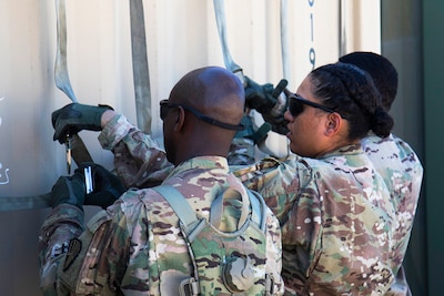 Soldiers from the 369th Sustainment Brigade work together to secure straps to the shipping containers that will be shipped to Kuwait at Fort Hood, Texas on September 16, 2016. Shipping containers contain equipment necessary for the 369th Sustainment Brigade’s deployment to Kuwait. (U.S. Army photo by Sgt. Cesar E. Leon)