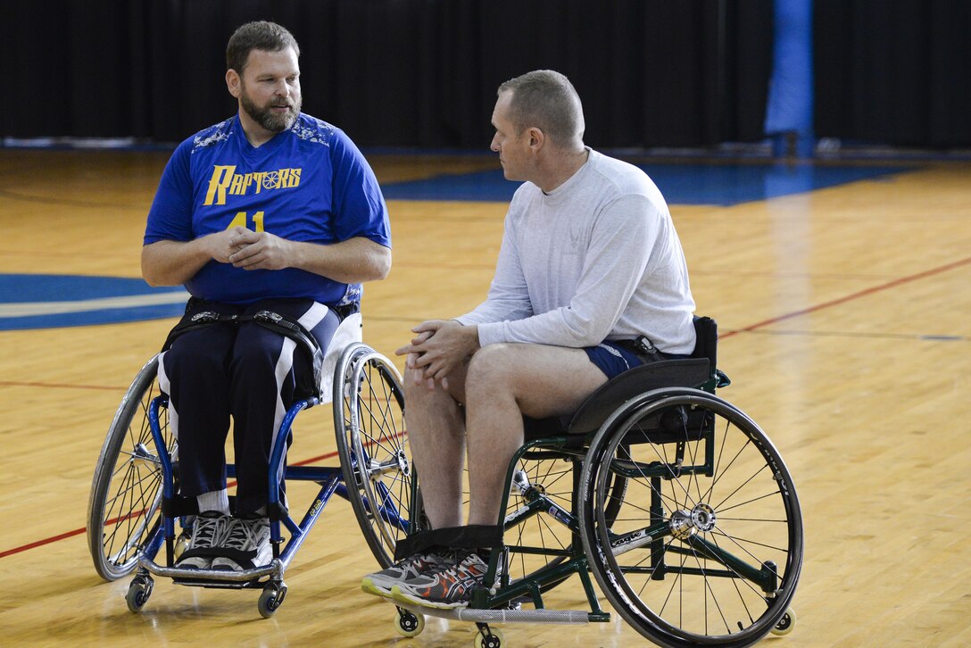 Greg Johnson, a member of the Raptors from Xenia, Ohio, talks with Chief Master Sgt. Jason France, Air Force Materiel Command command chief, prior to the start of the wheelchair basketball game held as part of the National Disability Awareness Month activities, Oct. 26, at Wright-Patterson Air Force Base. This is the 2nd year the base has hosted a wheelchair basketball game as part of the awareness month. (U.S. Air Force photo/ Wesley Farnsworth)