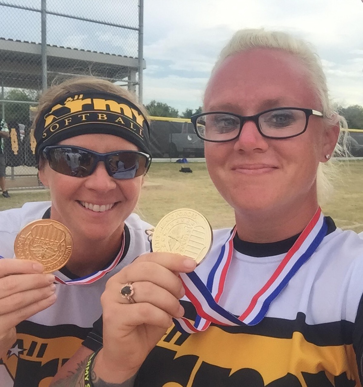 Army Sgt. Tiffany Oliver, left, a player with the All-Army Women’s Softball Team, and Army Staff Sgt. Nichole Higgins, right, head coach and a spectrum manager for the 101st Airborne Division Sustainment Brigade, show off their gold medals after winning the Armed Forces Championship tournament, Sept. 22, 2016, at Joint Base San Antonio-Fort Sam Houston, Texas. Army photo by Staff Sgt. Nichole Higgins