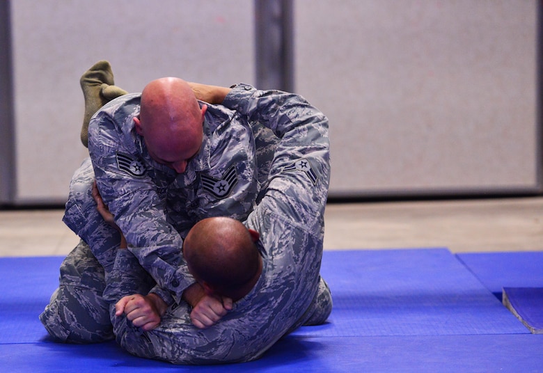 Staff Sgt. Nicholas Burdick restrains Airman 1st Class Tristan Ecalena during 50th Security Forces Squadron combatives training at Schriever Air Force Base, Colorado, Monday, Oct. 31, 2016. The training is an annual requirement for SFS members. (U.S. Air Force photo/Brian Hagberg)