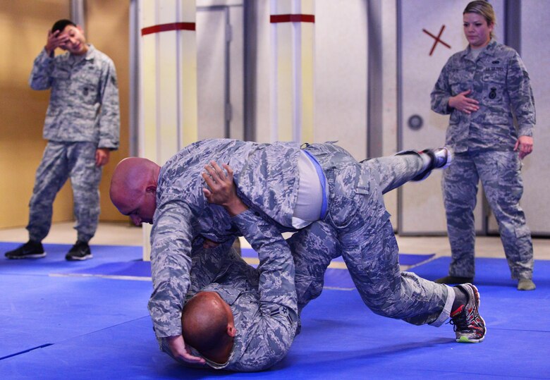 Airman 1st Class Tristan Ecalena escapes the grasp of Staff Sgt. Nicholas Burdick during 50th Security Forces Squadron combatives training at Schriever Air Force Base, Colorado, Monday, Oct. 31, 2016. The training comprises restraint, escape, submission and weapons retention. (U.S. Air Force photo/Brian Hagberg)