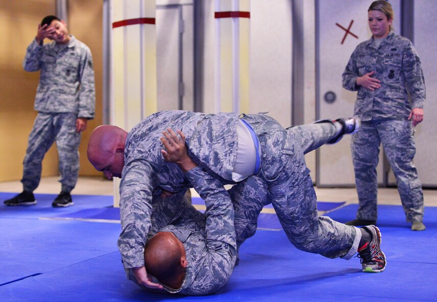Airman 1st Class Tristan Ecalena escapes the grasp of Staff Sgt. Nicholas Burdick during 50th Security Forces Squadron combatives training at Schriever Air Force Base, Colorado, Monday, Oct. 31, 2016. The training comprises restraint, escape, submission and weapons retention. (U.S. Air Force photo/Brian Hagberg)