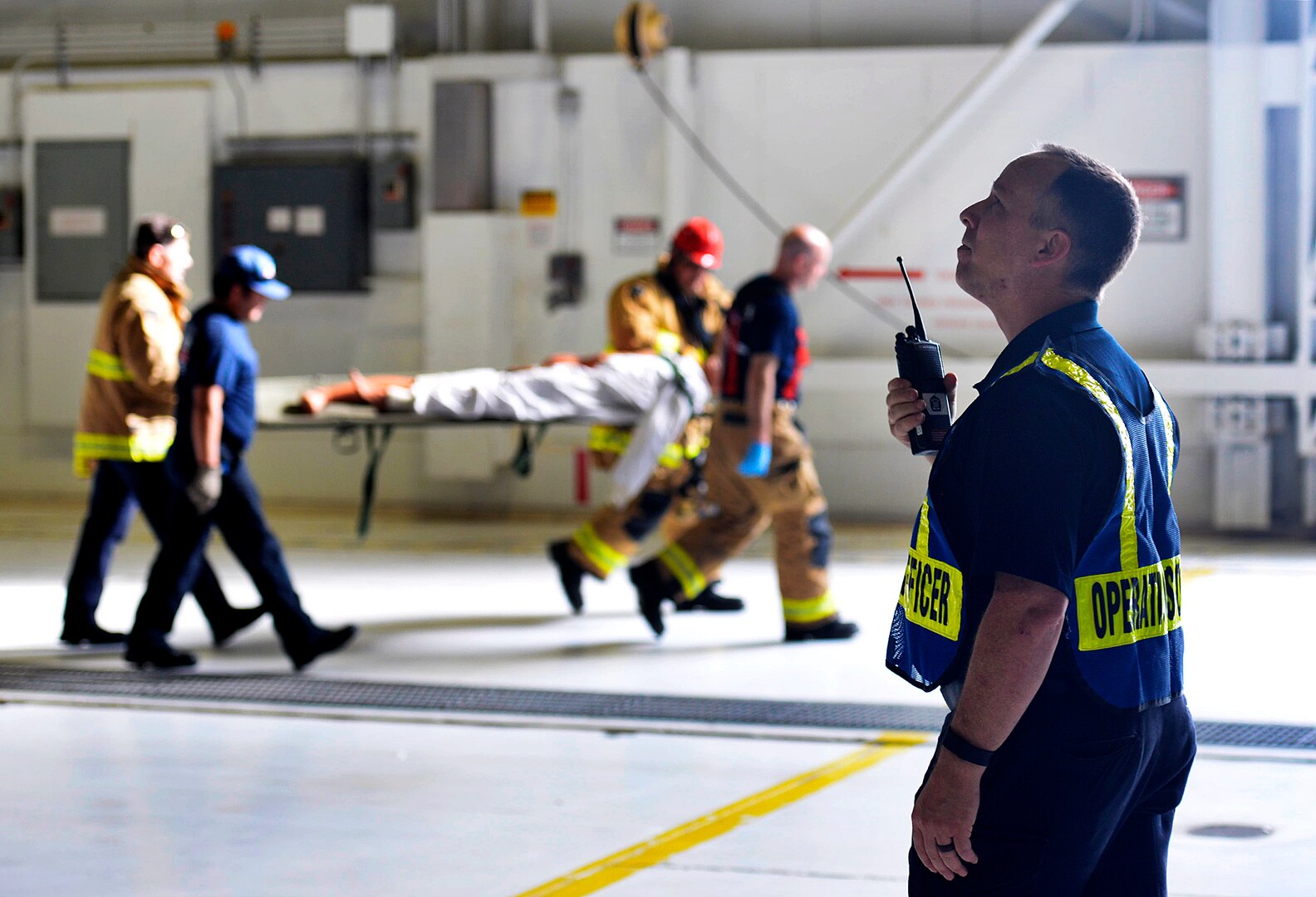 Aaron Ledsome, 502nd Civil Engineering Squadron station chief, oversees the firemen's response during the fuel extraction exercise Nov. 1, 2016 at Joint Base San Antonio-Lackland, Texas. Fireman with the 502nd Civil Engineering Squadron assisted in the extraction by safely securing the patient from the fuel tank and providing basic life support. The 433rd Airlift Wing's Maintenance Squadron conducted the fuel cell exercise as part of their annual training.  (U.S. Air Force photo by Benjamin Faske)