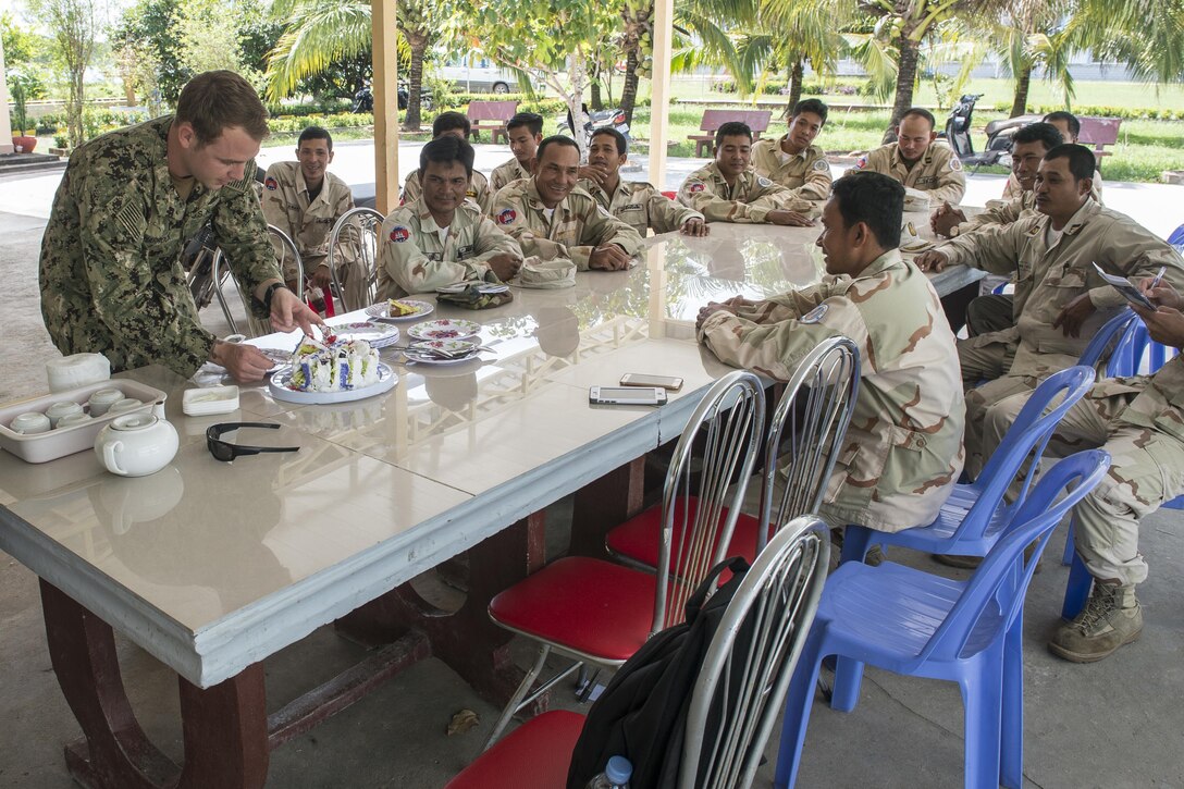 Navy Chief Petty Officer Kristopher Sharrock cuts a birthday cake from Cambodian sailors at the end of training Cooperation Afloat Readiness and Training Cambodia 2016 in Sihanoukville, Cambodia, Nov. 2, 2016. Navy photo by Petty Officer 1st Class Benjamin A. Lewis