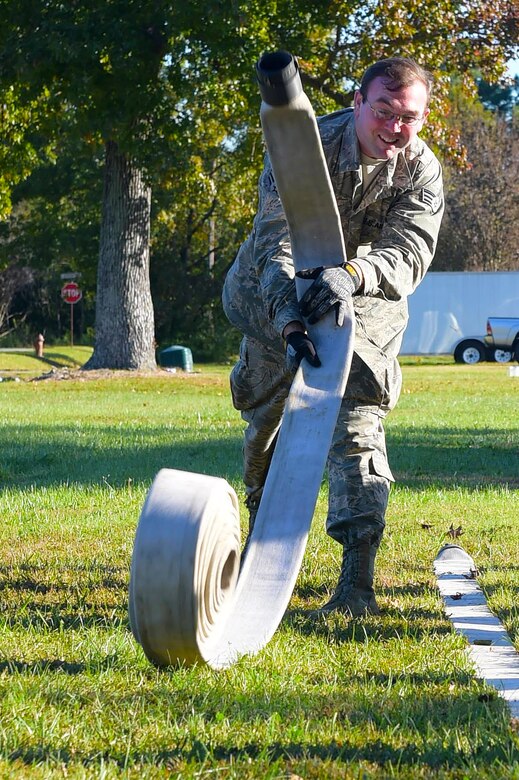 U.S. Air Force Senior Airman Matt Hargis, 633rd Civil Engineer Squadron electrical systems journeyman, throws a fire hose in an attempt to knock down bottles, during a Prime Base Engineering Emergency Force readiness challenge at Joint Base Langley-Eustis, Va., Oct. 25, 2016. Hargis, along with other 633rd CES members from different sections, took part in events that challenged them at different skills. (U.S. Air Force photo by Senior Airman Kimberly Nagle) 