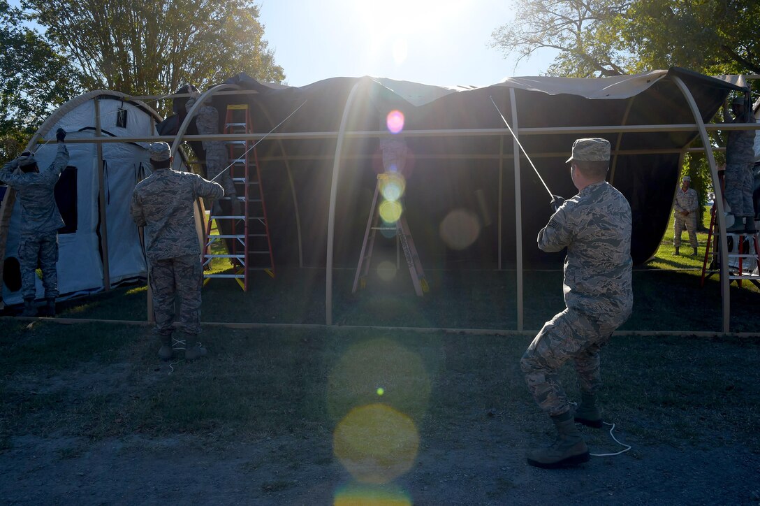 Members of the 633rd Civil Engineer Squadron set-up a small shelter system during a Prime Base Engineering Emergency Force readiness challenge at Joint Base Langley-Eustis, Va., Oct. 25, 2016. This part of the training was instructed by the structures shop, the instructors showed them how to properly put up and take down the small shelter system. (U.S. Air Force photo by Senior Airman Kimberly Nagle)