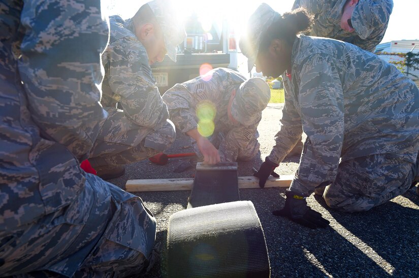 Members of the 633rd Civil Engineer Squadron participate at an electrical power production station during a Prime Base Engineering Emergency Force training at Joint Base Langley-Eustis, Va., Oct. 25, 2016. At this station, which was one of 12, they punched out and reeved nylon purchase tape through a tape connector. (U.S. Air Force photo by Senior Airman Kimberly Nagle) 