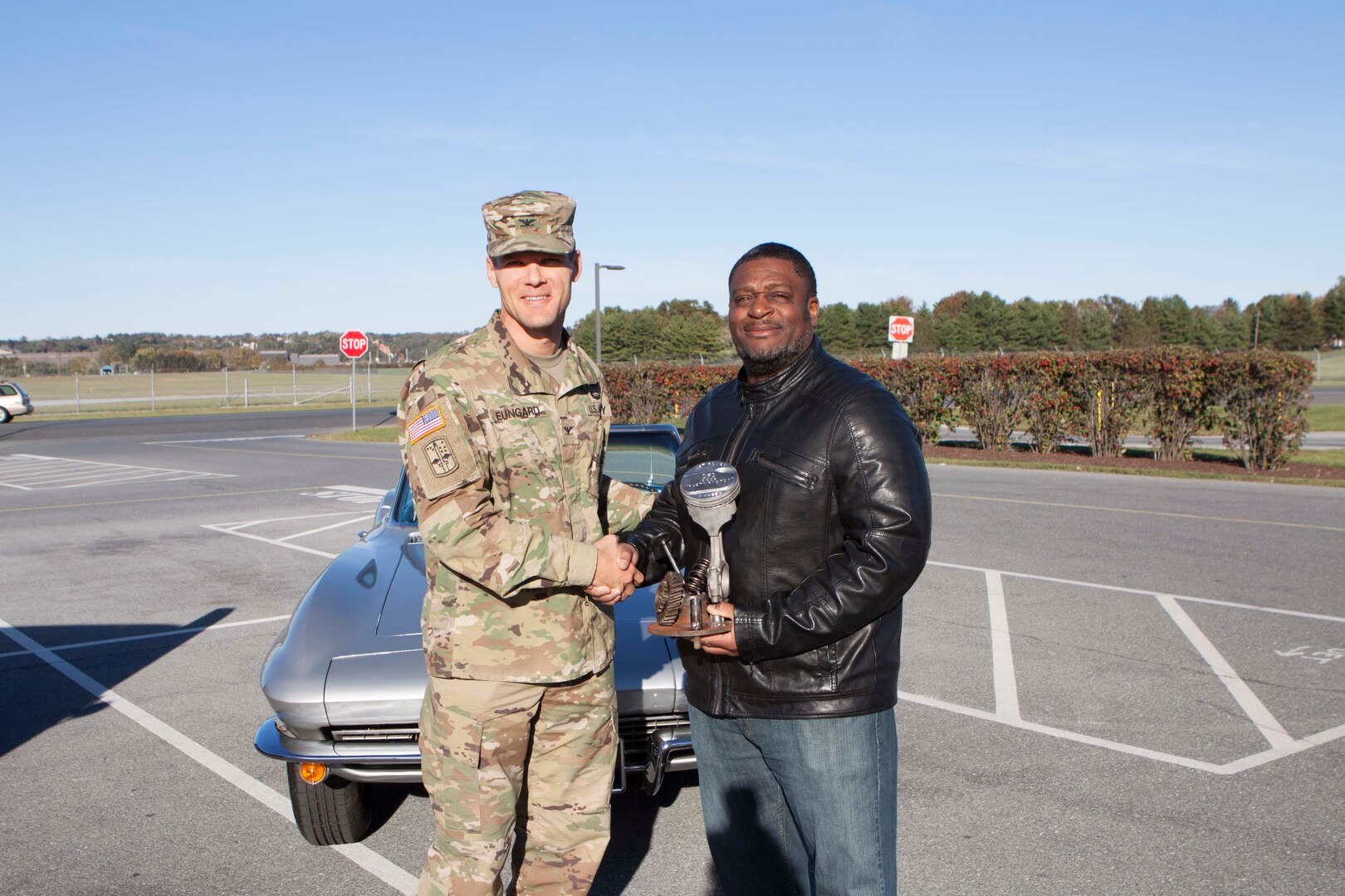 Army Col. Brad Eungard, DLA Distribution Susquehanna, Pa., commander presents Henry Johnson the “Rusty Piston” for his first place Corvette at the CFC Car Show on October 28.