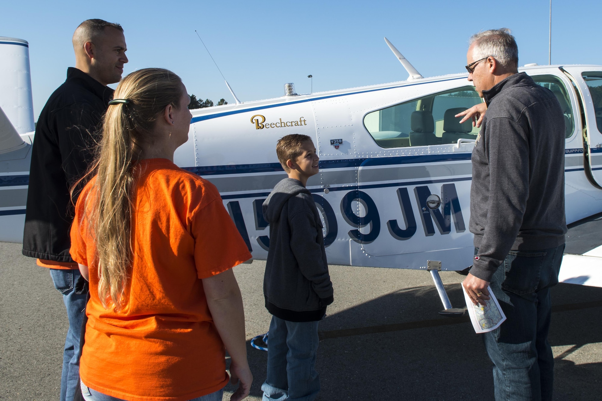 Greg Ricker, Goldsboro Wayne Aviation Association pilot, shows Master Sgts. Michael and Krystal Aponte, 4th Operations Support Squadron air traffic controllers, and their child around the aircraft they will be flying in during the annual Scare-a-Controller event, Oct. 29, 2016, at Wayne Executive Jetport in Goldsboro, North Carolina. Ricker explained various aspects of the aircraft before taking the Apontes on their incentive flight. (U.S. Air Force photo by Airman Shawna L. Keyes)