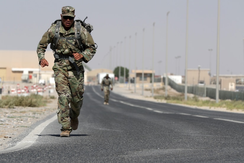 A staff sergeant runs with a 35-pound ruck during the four-mile ruck march to begin the 160th Signal Brigade NCO Week team competition at Camp Arifjan, Kuwait, Oct. 14, 2016. The competition featured four-Soldier teams from the brigade competing in several high-intensity events to win the top noncommissioned officer honors. (U.S. Army photo by Sgt. Brandon Hubbard)