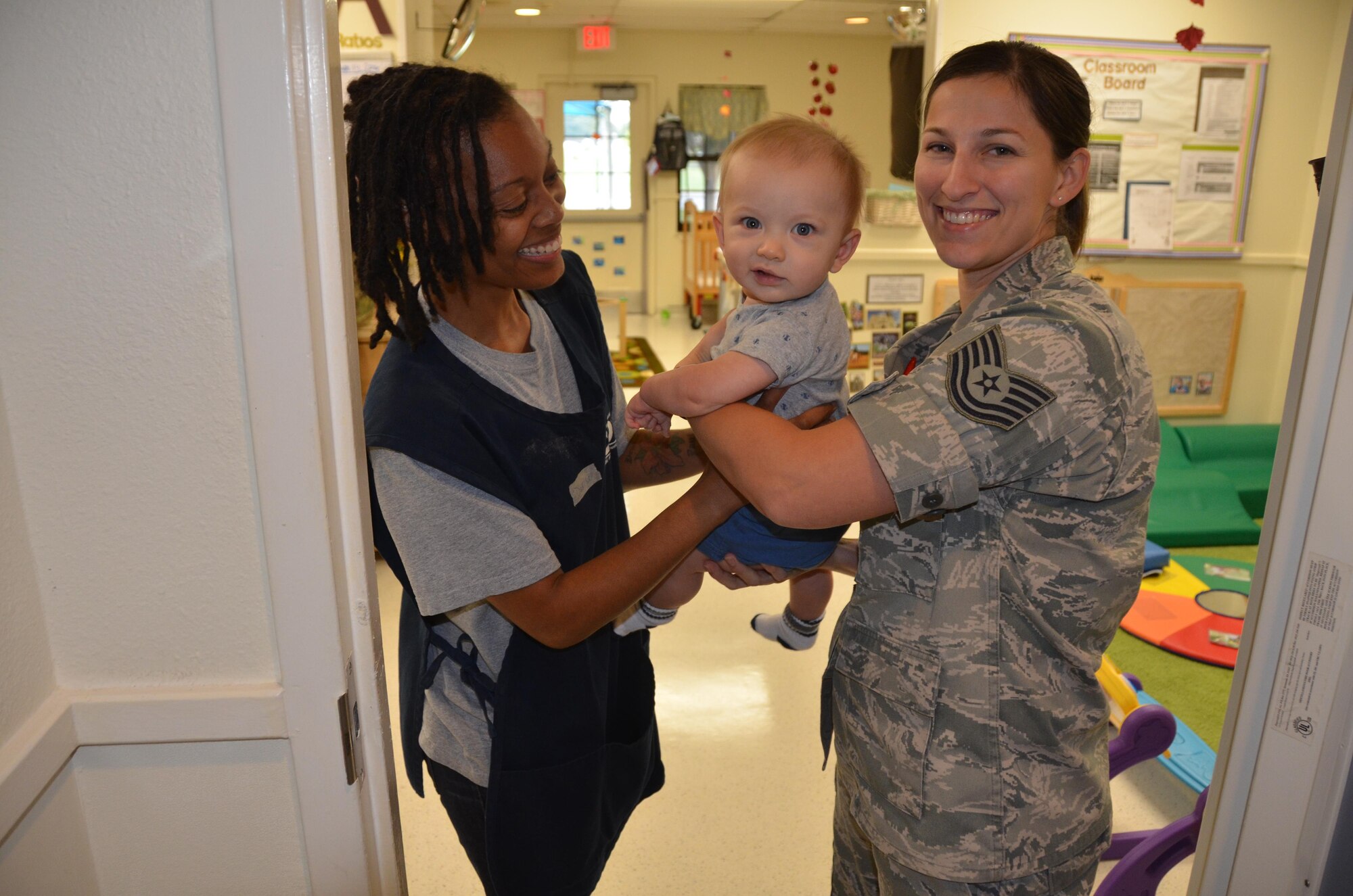 Technical Sgt. Crystal Dean drops off her son Isaiah, 6 months, to Denise Garces, lead teacher for Joint Base San Antonio-Fort Sam Houston’s Child Development Center. (U.S. Air Force Photo by Steve Warns)
