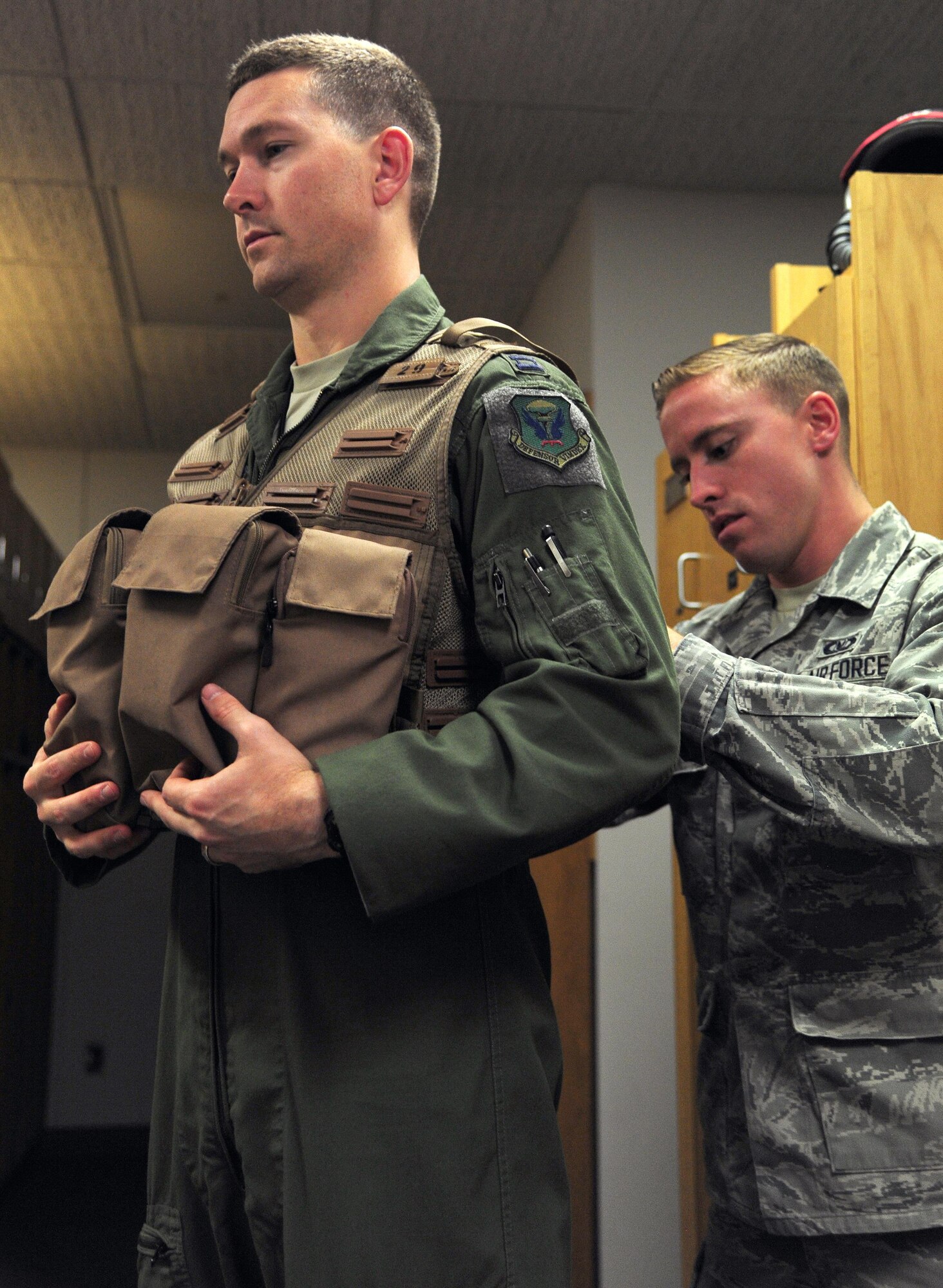 U.S. Air Force Senior Airman Adam Clapp, right, an aircrew flight equipment technician from the 509th Operations Support Squadron, adjusts the straps on an aircrew survival vest for Capt. Daniel Welch, a B-2 Spirit pilot from the 13th Bomb Squadron during Exercise Global Thunder 17 (GT17) at Whiteman Air Force Base, Mo., Oct. 25, 2016. GT17 is an annual command and control exercise designed to train U.S. Strategic Command forces and assess joint operational readiness. (U.S. Air Force photo by Senior Airman Joel Pfiester)