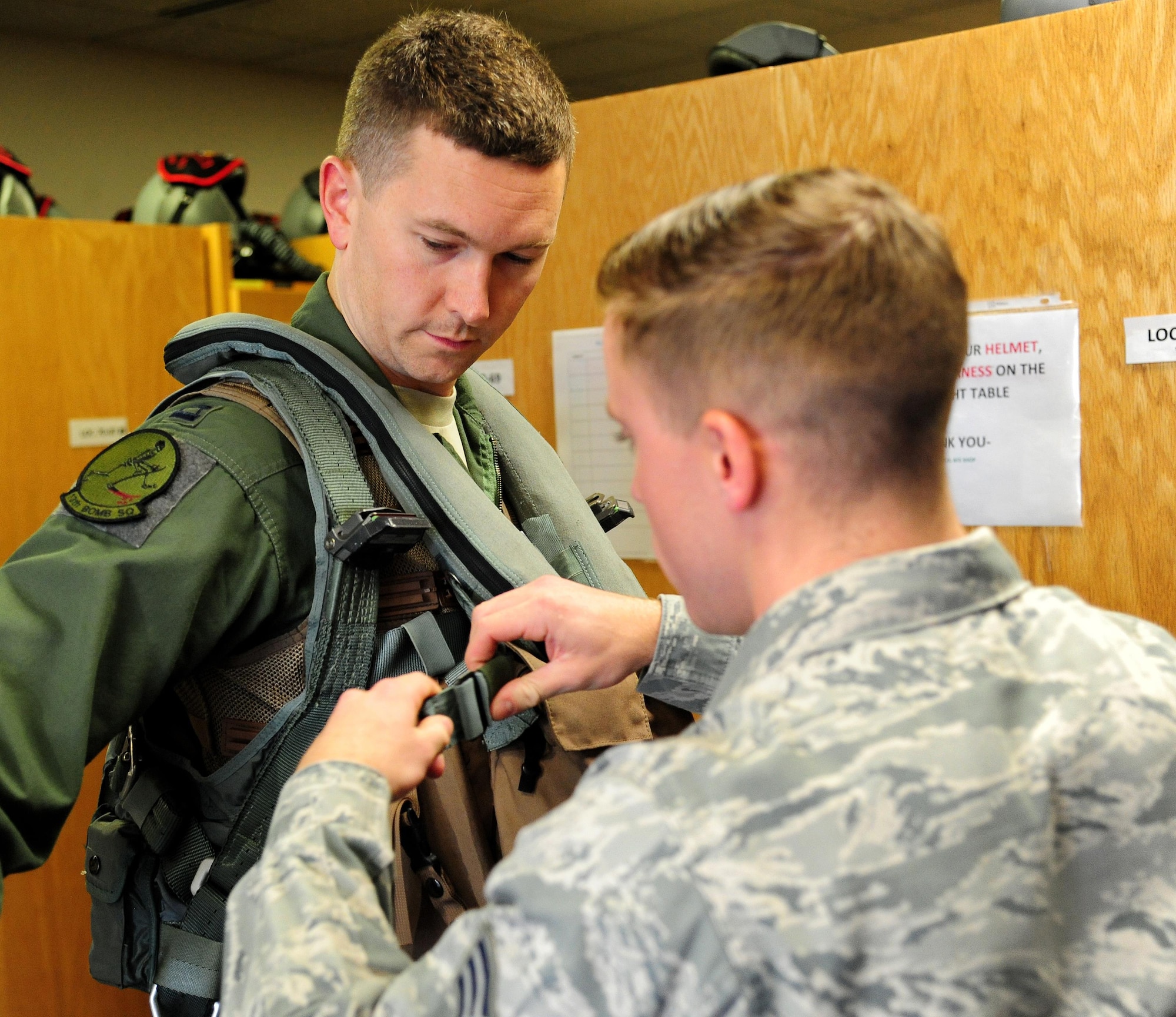 U.S. Air Force Senior Airman Adam Clapp, right, an aircrew flight equipment technician from the 509th Operations Support Squadron, tightens the straps of the aircrew survival vest on Capt. Daniel Welch, a B-2 Spirit pilot assigned to the 13th Bomb Squadron, during Exercise Global Thunder 17 (GT17) at Whiteman Air Force Base, Mo., Oct. 25, 2016. GT17 is an invaluable training opportunity to exercise all U.S. Strategic Command mission areas and create the conditions for strategic deterrence against a variety of threats.(U.S. Air Force photo by Senior Airman Joel Pfiester)