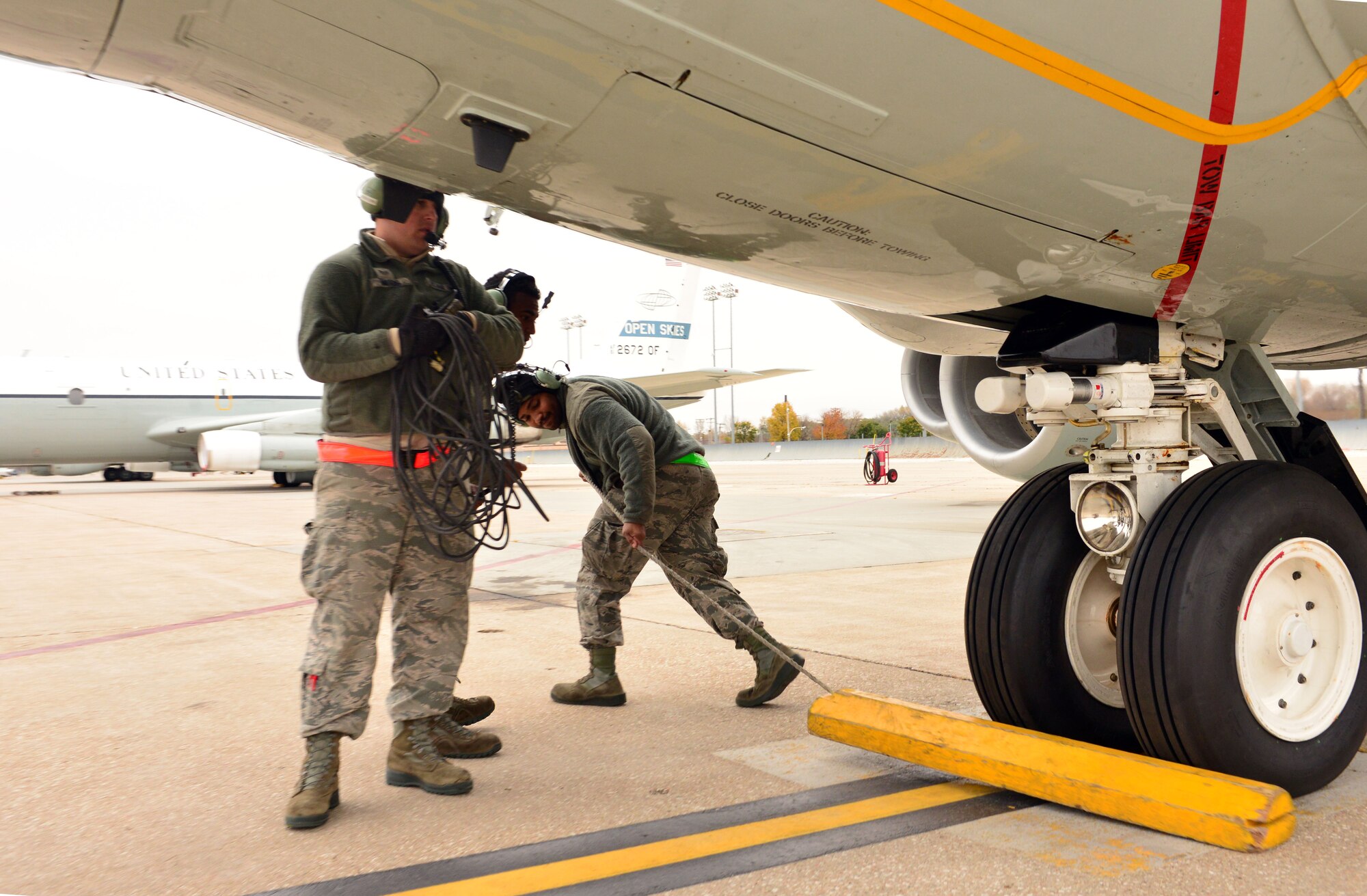 Staff Sgt. Riley Neads, Airman First Class Kejion Madden-Vaughn and Airman First Class Clinton Woods III (from left to right), crew chiefs with the 55th Maintenance Group, finish their preflight tasks, including removing wheel chocks, while preparing to launch an RC-135 V/W Rivet Joint aircraft during Global Thunder 17, U.S. Strategic Command’s annual command post and field training exercise, Oct. 30, 2016, at Offutt Air Force Base, Neb. The exercise provided training opportunities for USSTRATCOM-tasked components, task forces, units and command posts to deter and, if necessary, defeat a military attack against the United States and to employ forces as directed by the President. (U.S. Air Force Photo by Drew Nystrom)