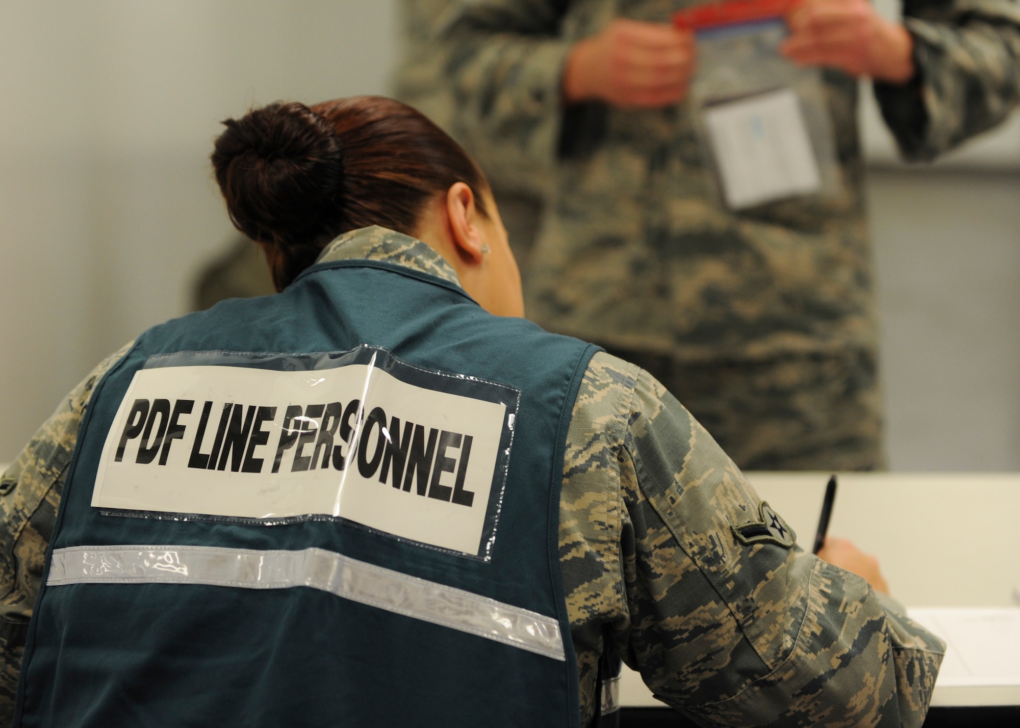 A member of the personnel deployment function (PDF) line checks the identification of a deployer during Exercise Global Thunder 17 (GT17) at Whiteman Air Force Base, Mo., Oct. 26, 2016. Exercises like GT17 involve extensive planning and coordination to provide unique training opportunities for assigned units and forces. (U.S. Air Force by Senior Airman Danielle Quilla)