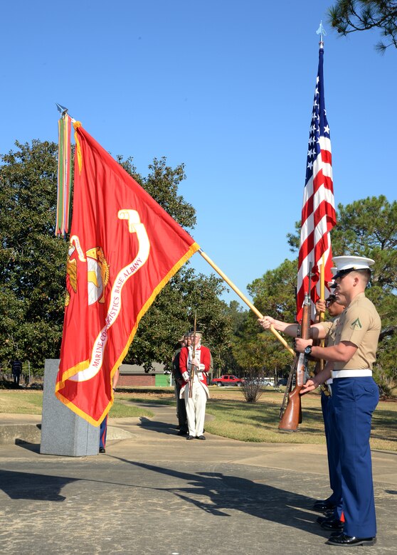 Marine Corps Logistics Base Albany Color Guard presents the colors while Marines, wearing various uniforms throughout Marine Corps history, render a salute during a birthday pageant at Covella Pond aboard Marine Corps Logistics Base Albany, Nov. 1.