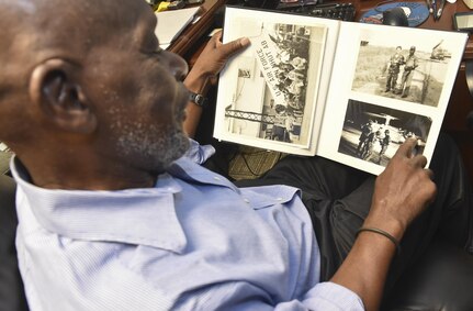 Mitchell Jenkins, chief of logistics at the 1st Combat Camera Squadron, and Vietnam veteran, reminisces while looking through a photo album Nov. 1, 2016, at Joint Base Charleston, South Carolina. Jenkins keeps an album full of photos from his career in Combat Camera. 