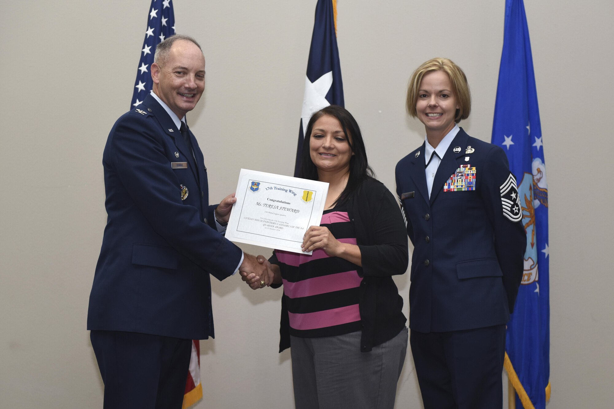 U.S. Air Force Col. Michael Downs, 17th Training Wing Commander, and Chief Master Sgt. Bobbie Riensche, 17th TRW Command Chief, present the Civilian Category I Non-Supervisory of the Quarter to Teresa Steward, 17th Medical Support Squadron, during the wing quarterly awards ceremony at the Event Center on Goodfellow Air Force Base, Texas, Oct. 31, 2016. (U.S. Air Force photo by Airman 1st Class Chase Sousa/Released)