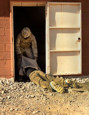 An Airman assigned to the 799th Security Forces Squadron drags a neutralized member of the opposing force into a building during a Fundamentals of Proficiency Fire and Close Quarters Battle course, Oct. 21, 2016, at Range 63C, Silver Flag Alpha, Nev. Members of the Nellis and Creech Air Force Base community volunteered to assist in simulating scenarios in a deployed environment. (U.S. Air Force photo by Airman 1st Class James Thompson)