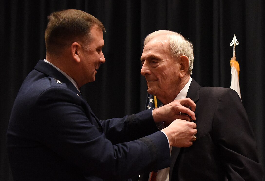 Maj. Gen. Christopher Bence, U.S. Air Force Expeditionary Center commander, pins the Silver Star on Maj. William “Joe” Schneider during a ceremony on Joint Base McGuire-Dix-Lakehurst, Nov. 1, 2016, for his actions while commanding an 18-plane bombing raid on Feb. 23, 1945 over Italy. (U.S. Air Force photo by Tech. Sgt. Jamie Powell)