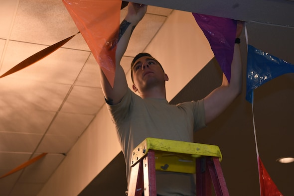 Senior Airman Daniel Tinsley, 790th Missile Security Forces Squadron tactical response force assaulter, hangs up decorations in the Trail’s End at F.E. Warren Air Force Base, Wyo., Oct. 27, 2016. Tinsley and other Airmen helped set up for an upcoming event. (Airman 1st Class Breanna Carter)