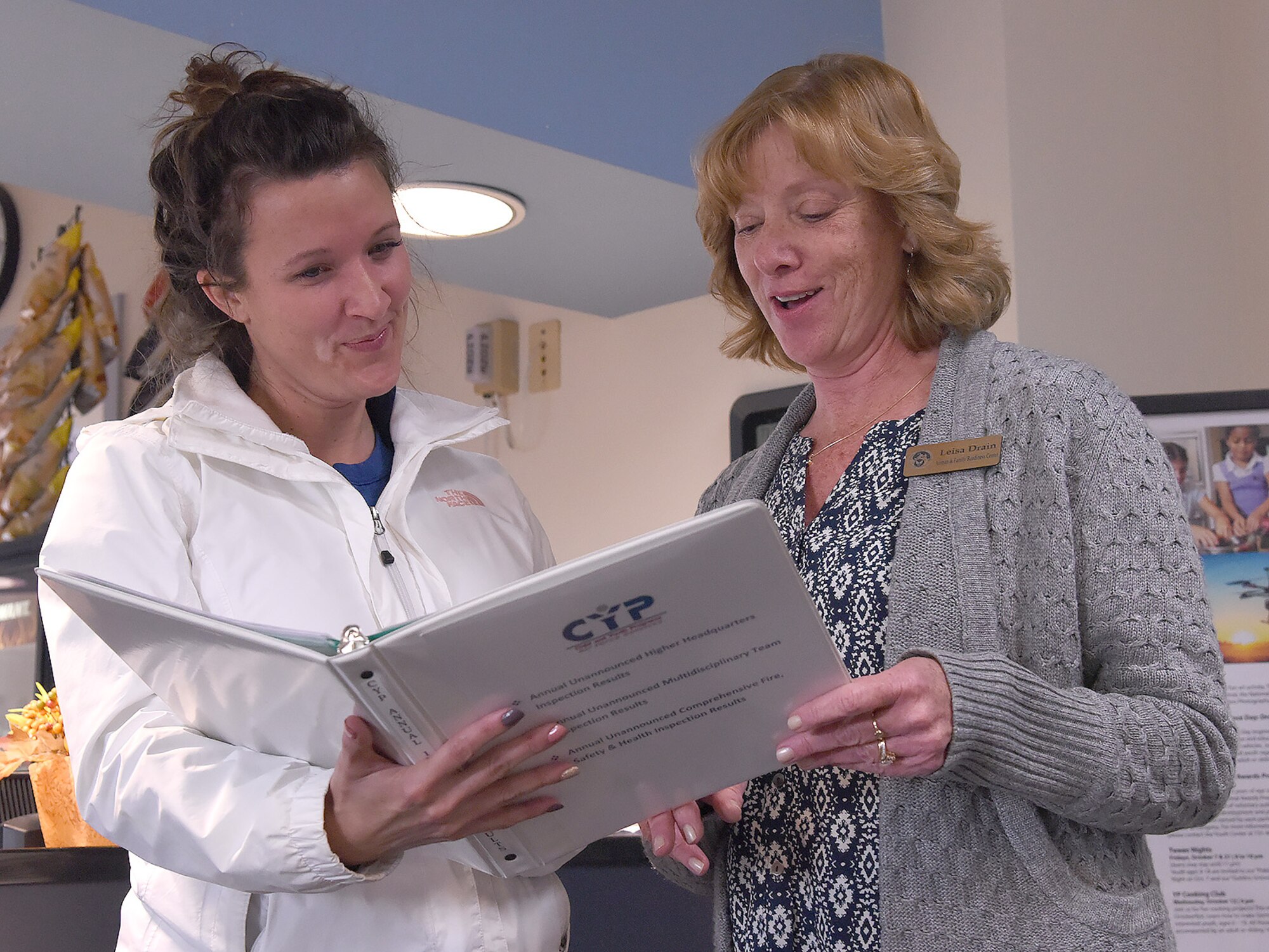 Leisa Drain, 341st Force Support Squadron Airman and Family Readiness Center school liaison officer, right, reviews an inspection book with Annie Sneed, 341st FSS school age coordinator, at the Youth Center Nov. 1, 2016, at Malmstrom Air Force Base, Mont. The SLO is required to be informed of inspectable items for any upcoming inspections. (U.S. Air Force photo/Senior Airman Jaeda Tookes)