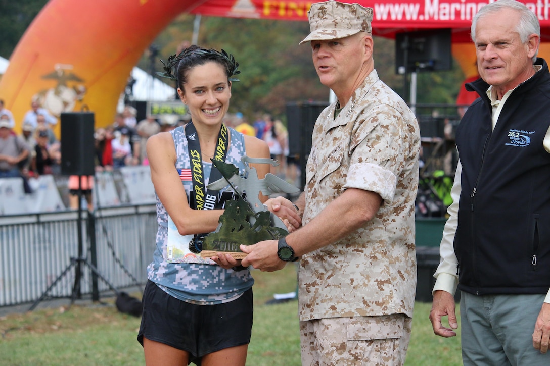 Army Capt Meghan Curran receives the 2nd Place Marine Corps Marathon award from the Commandant of the Marine Corps, General Robert Neller. The 2016 Armed Forces Marathon is held in conjunction with the 41st Marine Corps Marathon on 30 October in Washington, D.C.