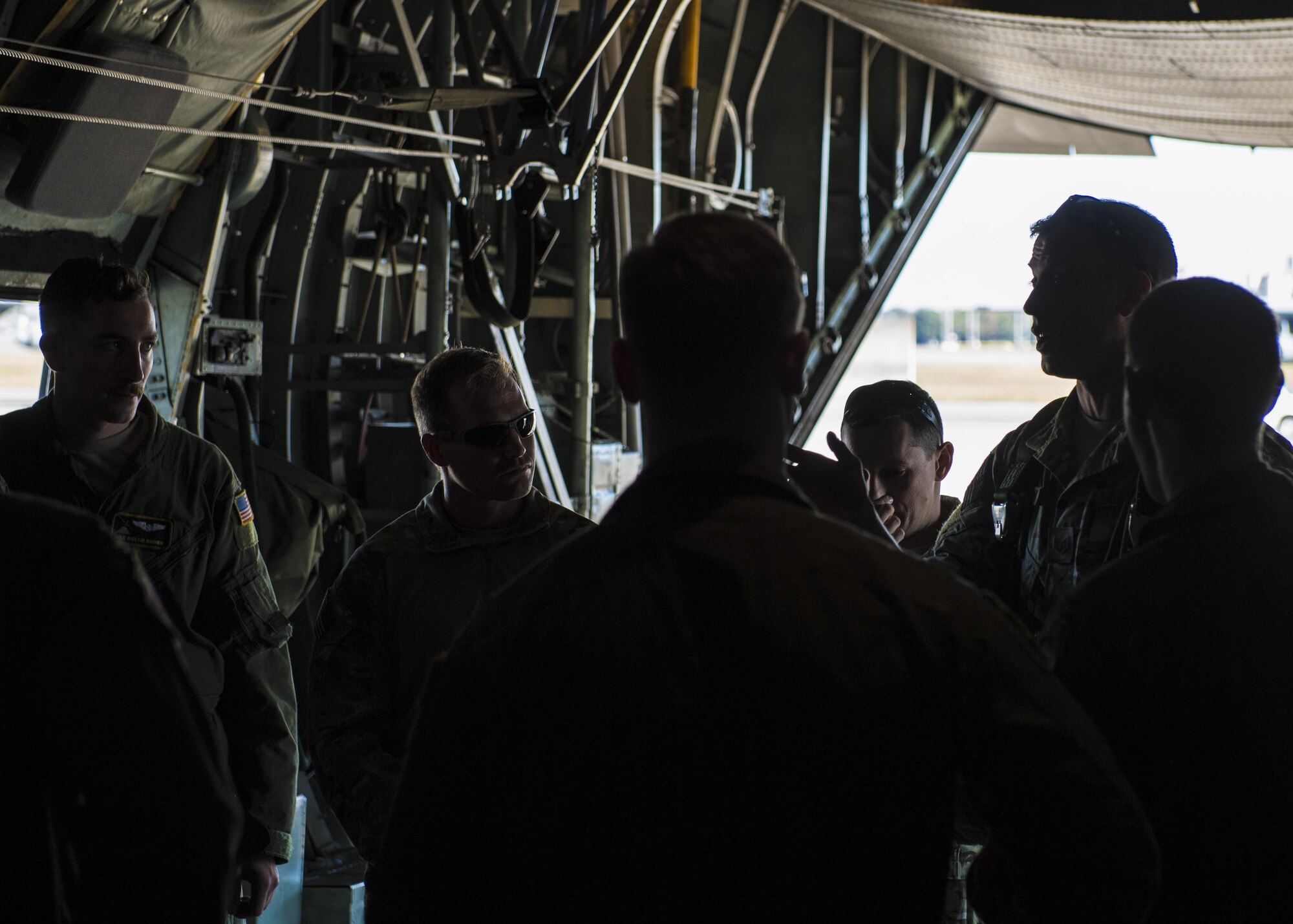 374th Operations Support Squadron survival, evasion, resistance and escape specialists coordinate with pilots on a personnel drop training exercise before takeoff in a C-130 Hercules on 26 Oct. 2016, at Yokota Air Base, Japan. The SERE specialists are trained for contingency situations, such as evading and escaping capture behind enemy lines. (U.S. Air Force photo by Airman 1st Class Donald Hudson/Released)
