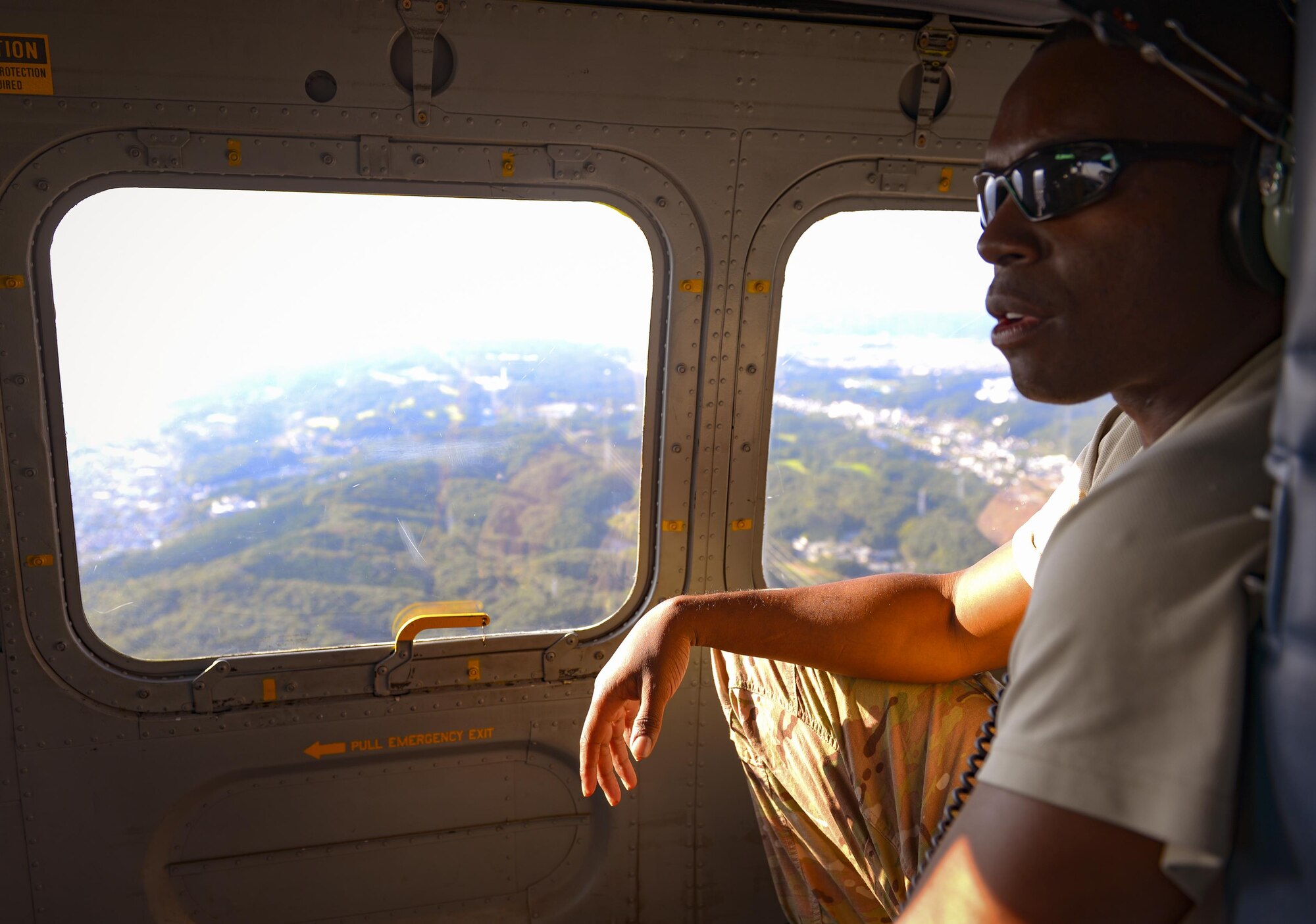 Tech. Sgt. Venie Joshua, 353rd Special Operations Support Squadron, transits in a UH-1 Iroquois over the Kanto Plain region, Japan, Oct. 26, 2016. Joshua was one of the Survival, Evasion, Resistance and Escape trainees who received hoist training to meet qualifications and sharpen the skills of all related personnel. (U.S. Air Force photo by Airman 1st Class Elizabeth Baker/Released)
