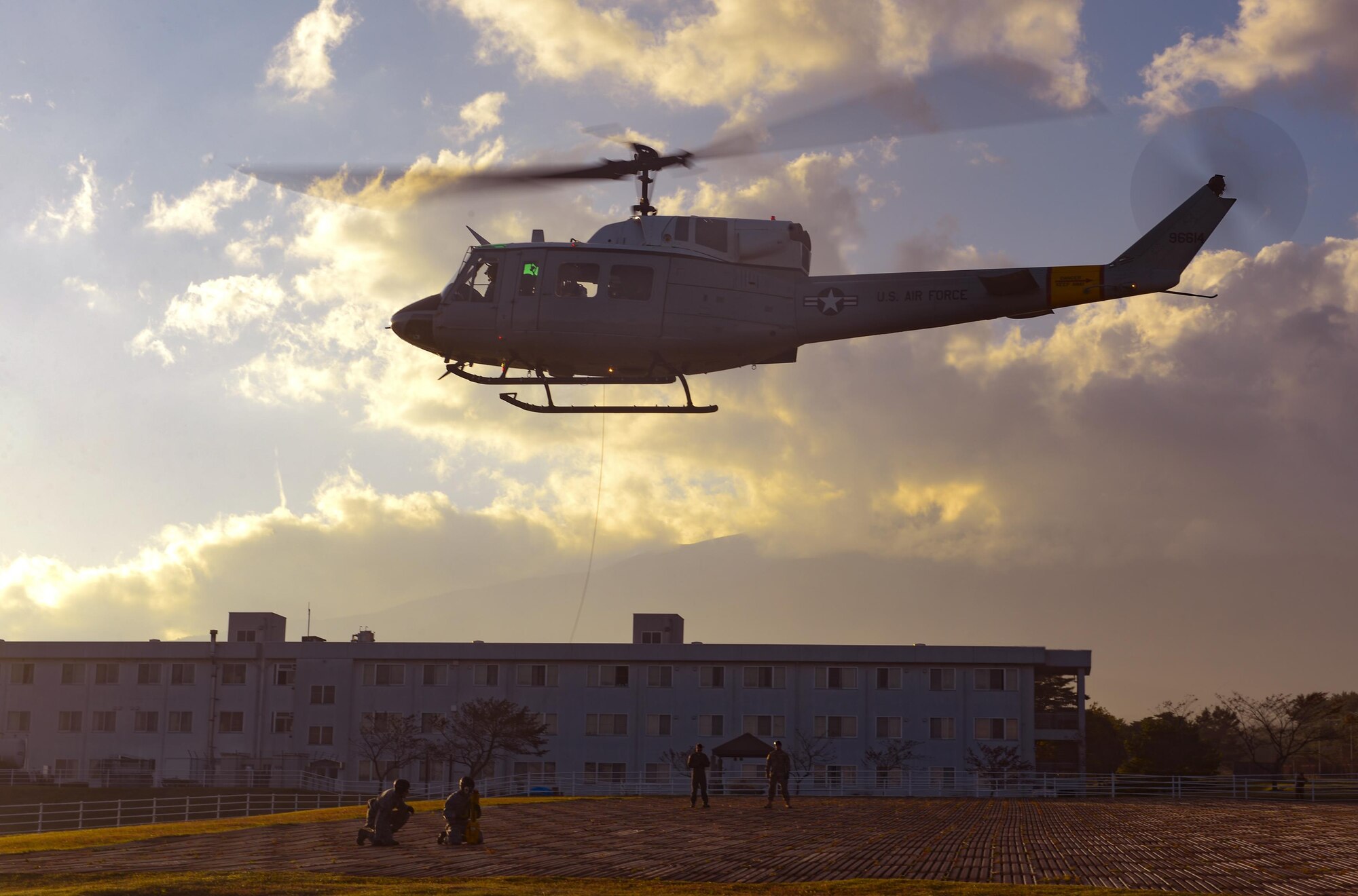 Members of the 459th Airlift Squadron prepare to hoist Survival, Evasion, Resistance and Escape trainees into a UH-1 Iroquois helicopter. Training on the hoist helps keep the air crew, SERE instructor and trainees qualified on their respective tasks. (U.S. Air Force photo by Airman 1st Class Elizabeth Baker/Released)