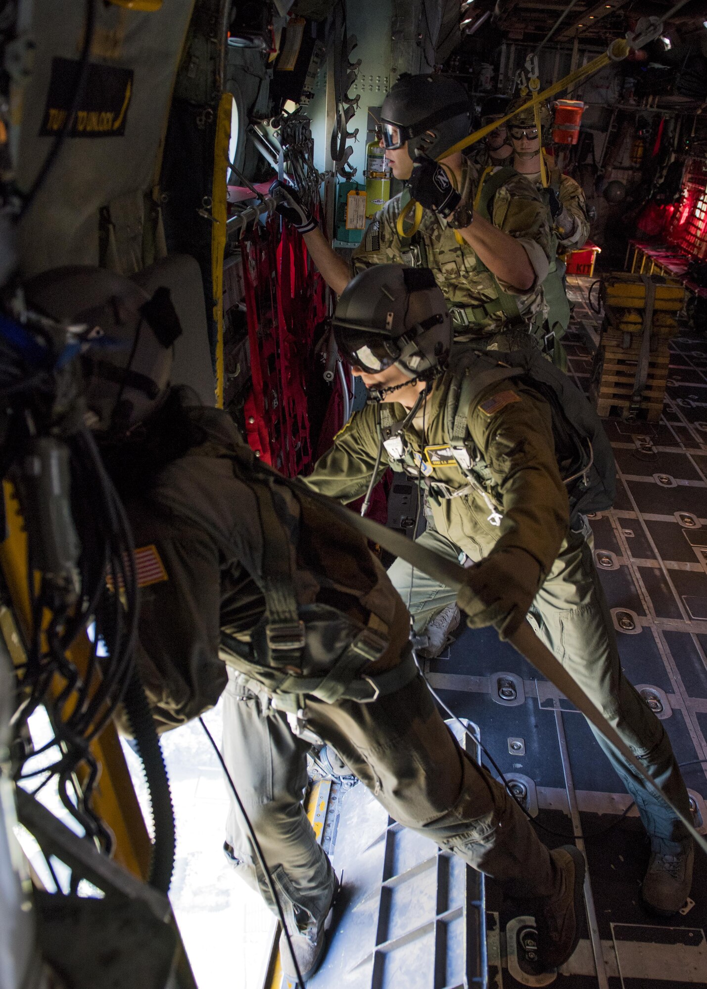 36th Airlift Squadron loadmasters open the troop door on a C-130 Hercules while 374th Operations Support Squadron survival, evasion, resistance and escape specialists wait to perform a static line parachute jump during a personnel drop training exercise on 26 Oct. 2016, at Yokota Air Base, Japan. The training not only allowed the SERE personnel to practice jumping, it helped loadmasters and other aircrew members perform personnel drop training. (U.S. Air Force photo by Airman 1st Class Donald Hudson/Released)