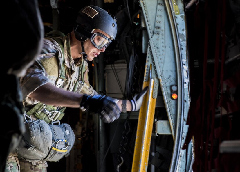 Staff Sgt. Justin Bender, 374th Operations Support Squadron survival, evasion, resistance and escape specialist prepares to perform a static line jump out of a C-130 Hercules on 26 Oct. 2016, at Yokota Air Base, Japan. SERE specialists conduct regular jump training to stay qualified and mission ready. (U.S. Air Force photo by Airman 1st Class Donald Hudson/Released)