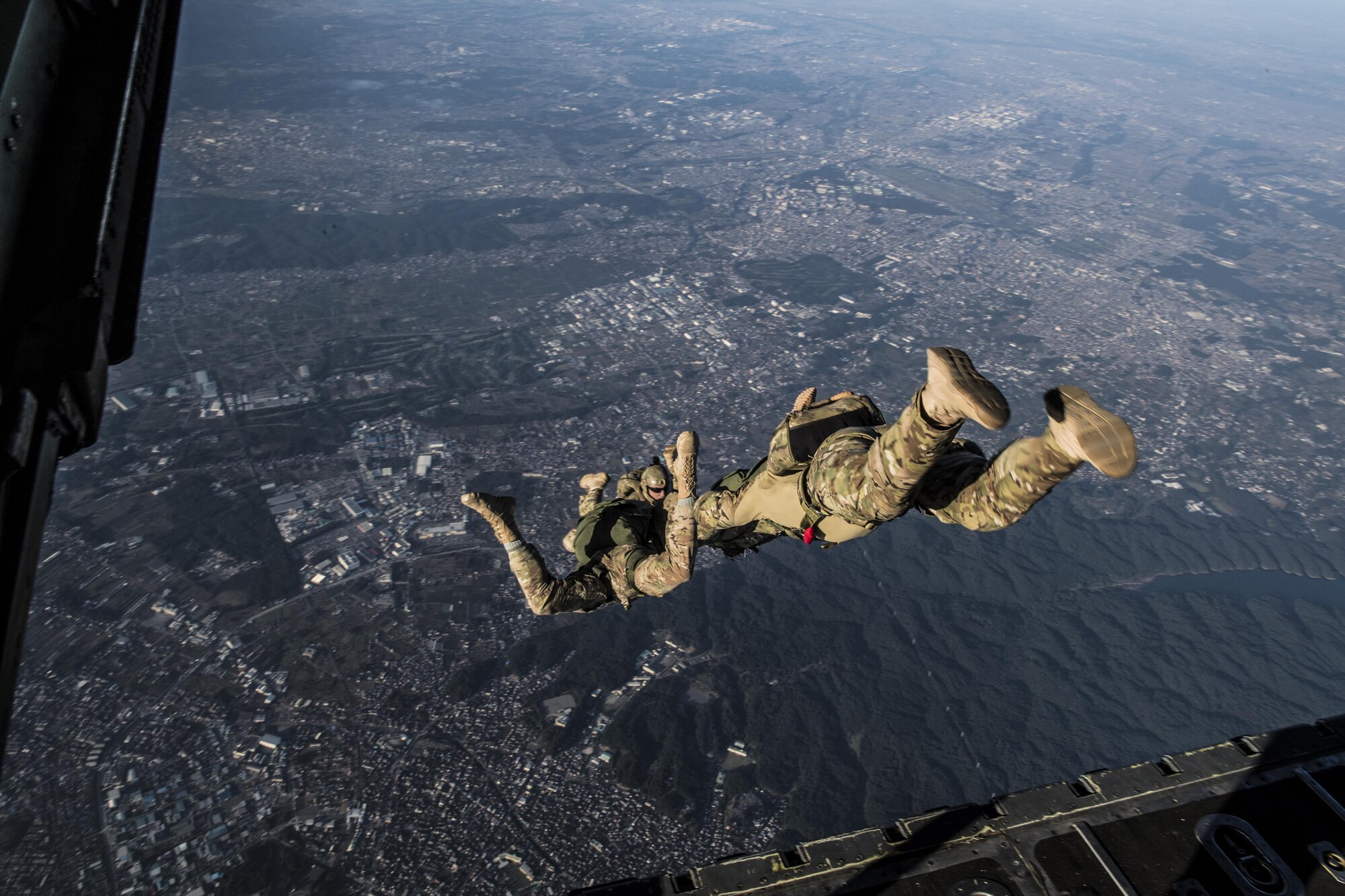 374th Operations Support Squadron survival, evasion, resistance and escape specialists free fall during a high altitude low opening parachute drop after jumping out of a C-130 Hercules 26 Oct. 2016, at Yokota Air Base, Japan. The SERE specialists are trained for contingency situations, such as evading and escaping capture behind enemy lines. (U.S. Air Force photo by Airman 1st Class Donald Hudson/Released)