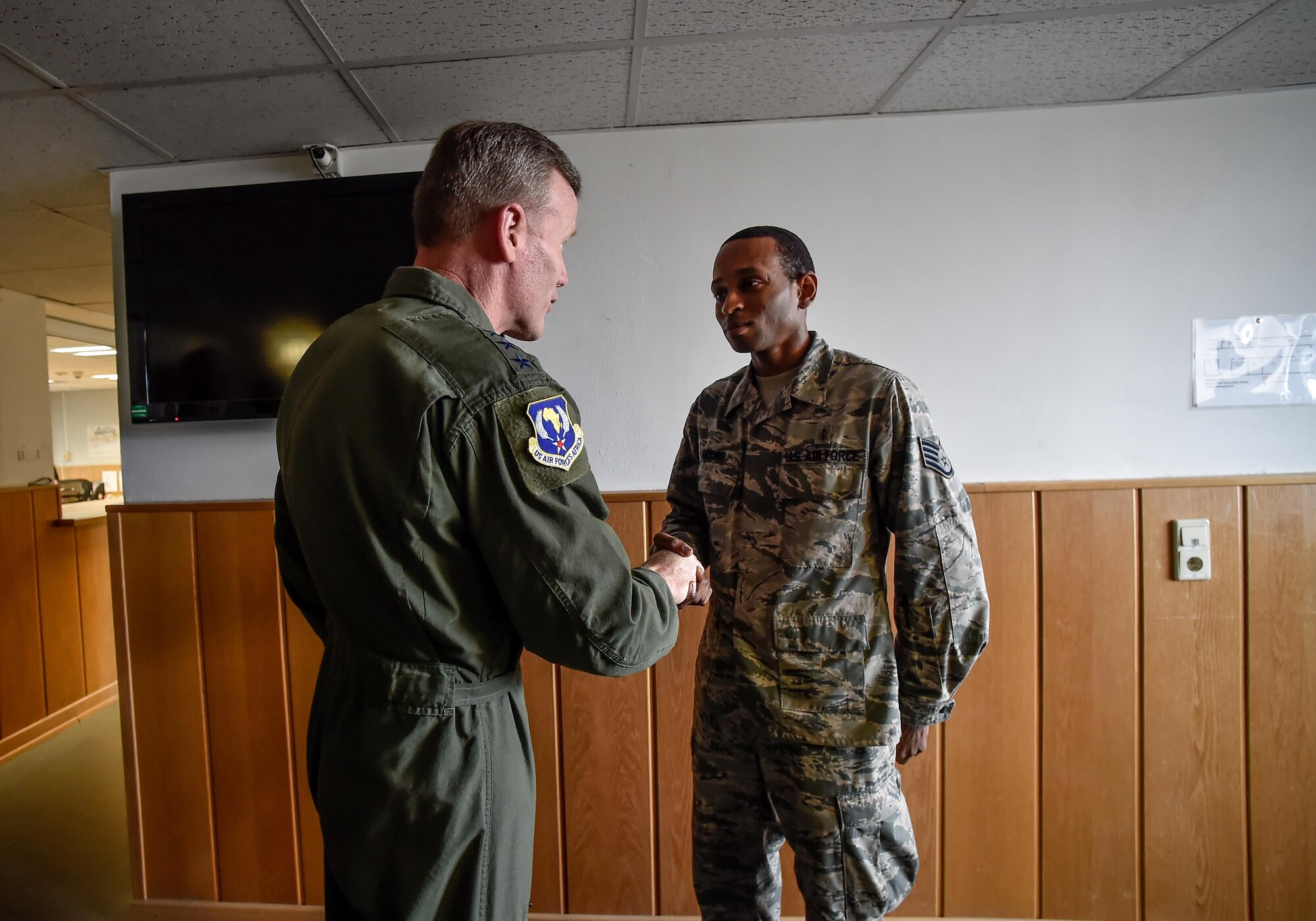 Staff Sgt. Joshua Moore, 86th Medical Support Squadron pharmacy technician, receives a coin from with Gen. Tod Wolters, U.S. Air Forces in Europe and Air Forces Africa commander at Ramstein Air Base, Germany, Nov. 1, 2016. Moore’s team developed an innovative solution to the needs of the flying community for high-altitude missions and shared his story with Wolters.  (U.S. Air Force photo by Senior Airman Nicole Keim)
