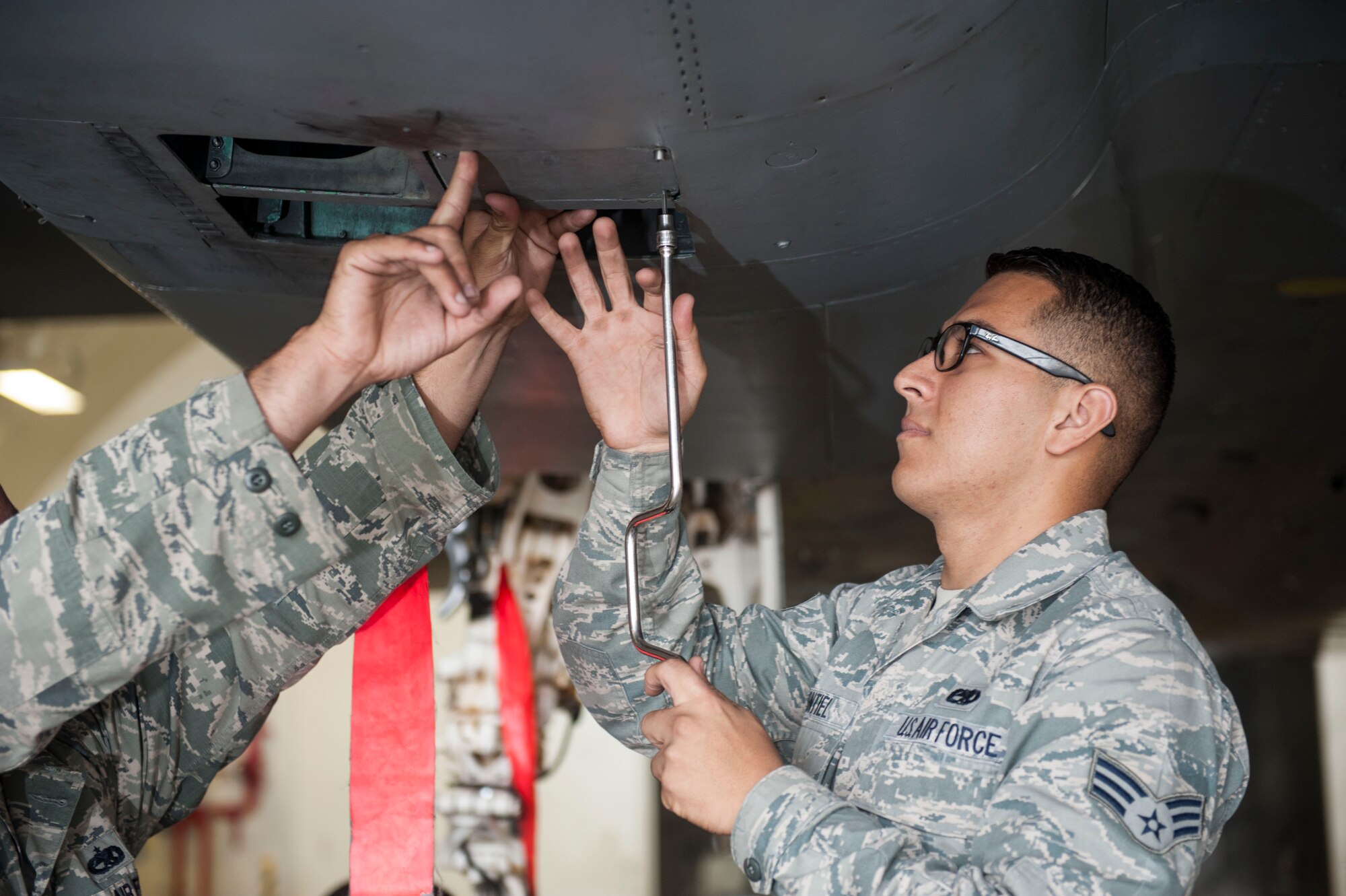 U.S. Air Force Senior Airman Jacob Montiel and Staff Sgt. Nicholas McCants, 44th Aircraft Maintenance Unit load crew members, fasten a panel on an F-15 Eagle Nov. 2, 2016, at Kadena Air Base, Japan. The 44th AMU conducted weapons load training, a monthly evaluation performed to maintain readiness for real-world missions. (U.S. Air Force photo by Senior Airman Lynette M. Rolen/Released)