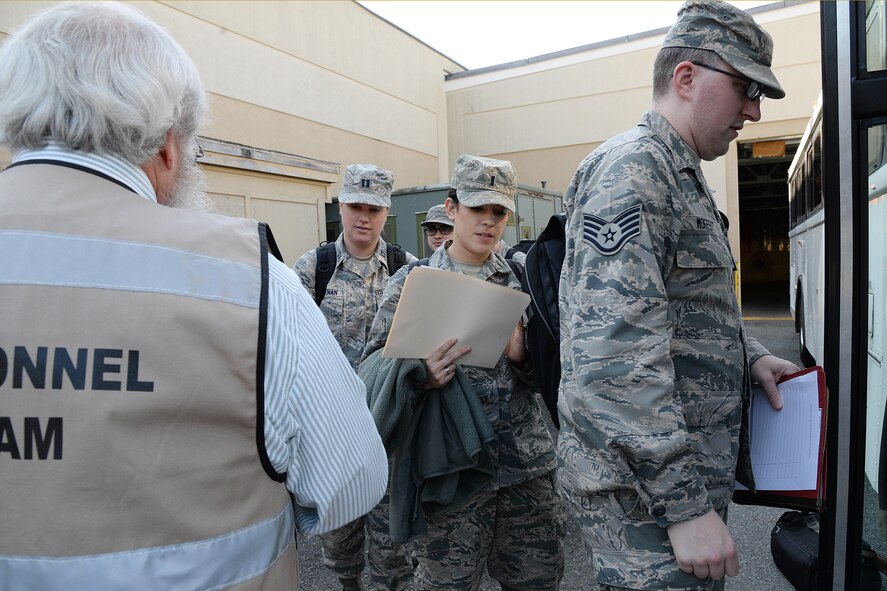 Airmen board a bus during a deployment processing exercise at Hanscom Air Force Base, Mass., Nov. 2. Evaluators ran through exercises to test base personnel on readiness, including deployment procedures. (U.S. Air Force photo by Linda LaBonte Britt)