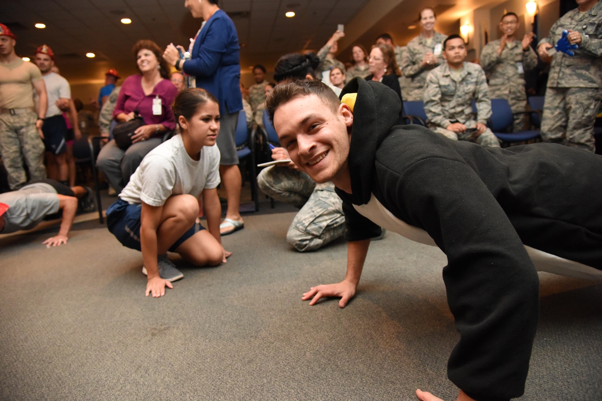 Airman 1st Class Garrett Redmond, 81st Diagnostic and Therapeutics Squadron radiology technician, smiles while doing push-ups during the 81st Medical Group Push-up Competition at the Keesler Medical Center Don Wylie Auditorium Nov. 1, 2016, on Keesler Air Force Base, Miss. Seven five-person teams competed in the event pushing out a total of 6,272 push-ups. The 81st Dental Squadron was this year’s winner with 1,127 push-ups. The Airmen who participated in the event raised money to support the Krewe of Medics Mardi Gras Ball. (U.S. Air Force photo by Kemberly Groue/Released)
