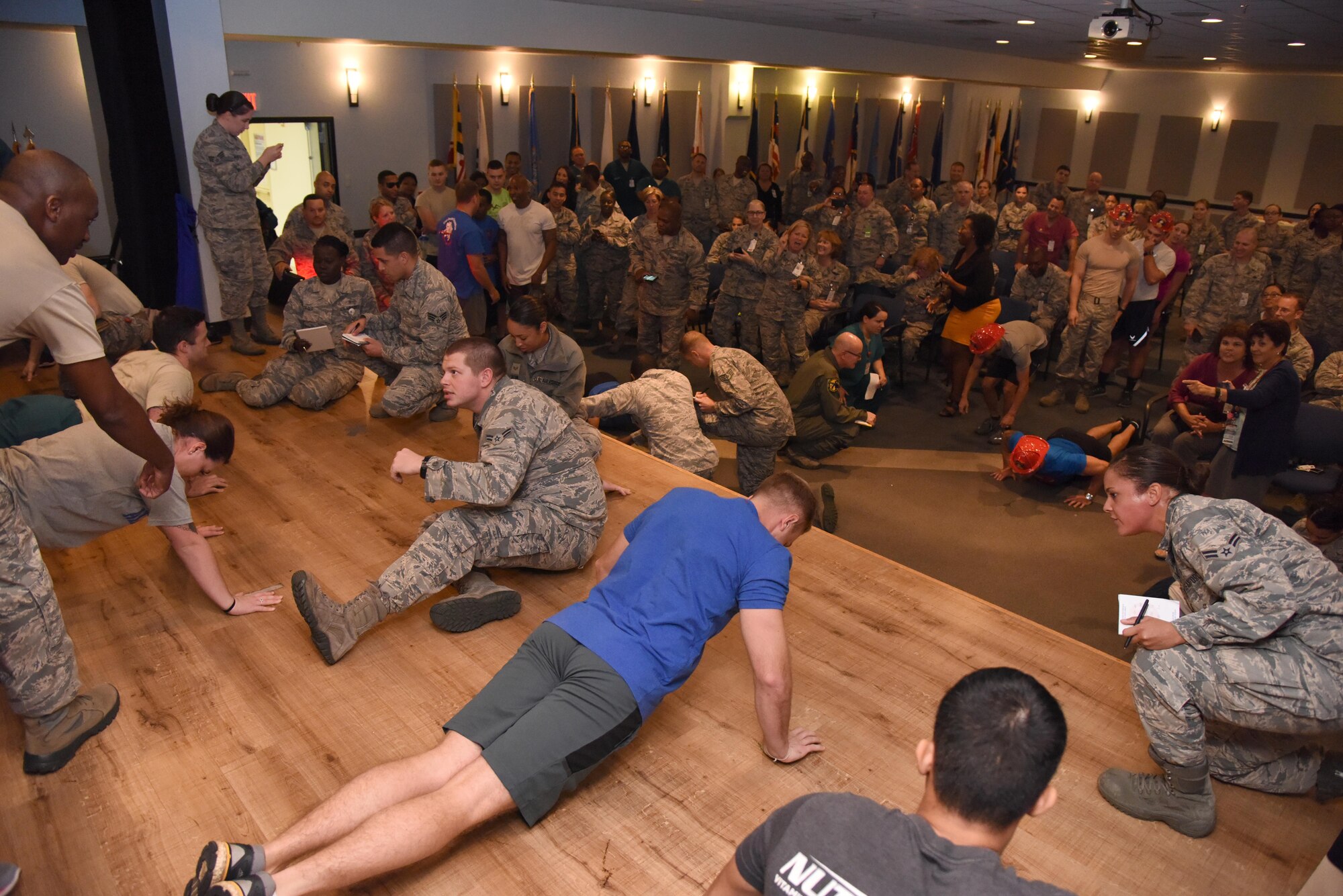 Members of the 81st Medical Group participate in the 81st MDG Push-up Competition at the Keesler Medical Center Don Wylie Auditorium Nov. 1, 2016, on Keesler Air Force Base, Miss. Seven five-person teams competed in the event pushing out a total of 6,272 push-ups. The 81st Dental Squadron was this year’s winner with 1,127 push-ups. The Airmen who participated in the event raised money to support the Krewe of Medics Mardi Gras Ball. (U.S. Air Force photo by Kemberly Groue/Released)
