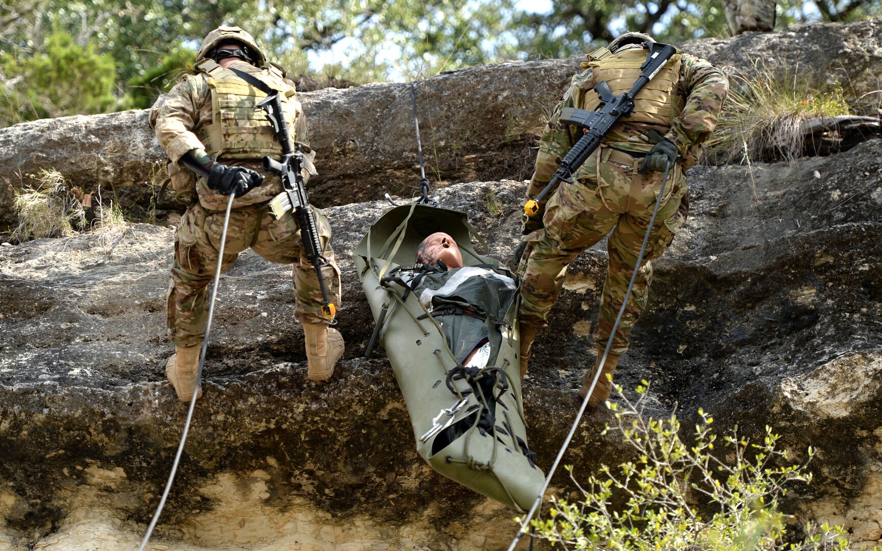 A combat medic team slowly rappels a simulated patient down a 25-foot cliff during the Best Medic Competition at Joint Base San Antonio-Camp Bullis Oct. 25.