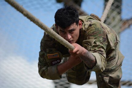 An Army combat medic bears down as he crosses the rope bridge portion of the obstacle course during the last day of the Best Medic Competition at JBSA-Camp Bullis Oct. 27.