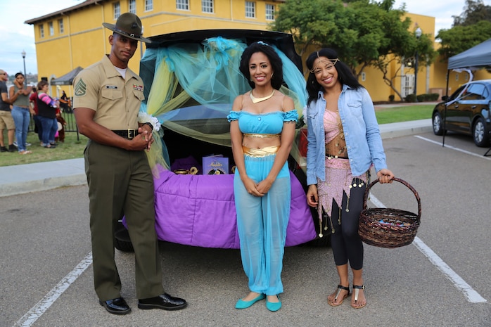 Staff Sergeant Josue A. Deleon, drill instructor, 1st Recruit Training Battalion, stands at a vehicle that was decorated for the Marine Corps Community Services' annual Trunk or Treat event at Marine Corps Recruit Depot San Diego, Oct. 28. The event allowed families and children to wear costumes and collect candy in a safe environment.
