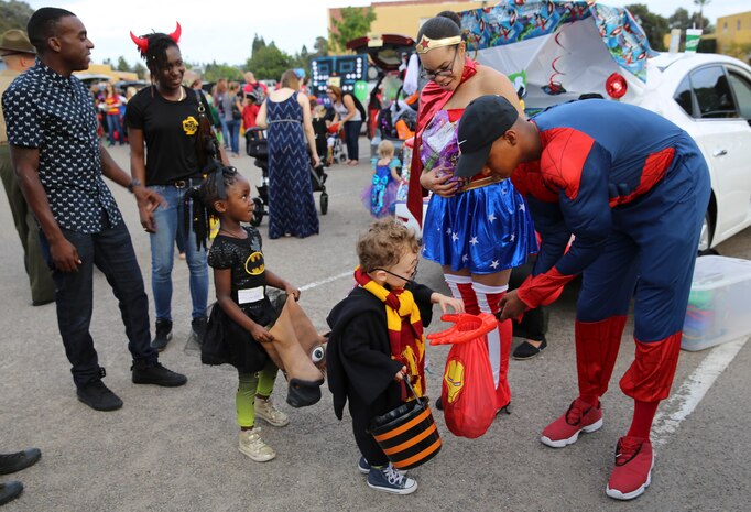 Postal Marines hand out candy during the Marine Corps Community Service’s annual Trunk or Treat event at Marine Corps recruit Depot San Diego, Oct. 28. Several vehicles and volunteers gathered in a parking lot to hand out candy to young trick or treaters. 