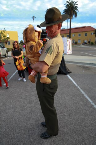 A drill instructor and his child collect candy during the Marine Corps Community Service’s annual Trunk or Treat event at Marine Corps Recruit Depot San Diego, Oct. 28. The event allowed families and children to wear costumes and collect candy in a safe environment.