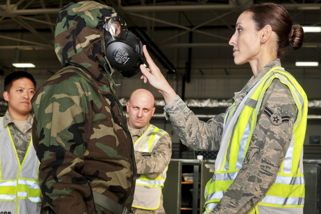 Air Force Airman 1st Class Dannielle Garcia, right, assists Airman 1st Class Jacqueline Garcia, with a demonstration of the proper wear of chemical protective equipment during training at Joint Base McGuire-Dix-Lakehurst, N.J., Oct. 30, 2016. The airmen are assigned to the New Jersey Air National Guard's 108th Wing Emergency Management Office. Air National Guard photo by Tech. Sgt. Matt Hecht